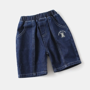 Détail d'un short en jean enfant avec taille élastique et broderie de chien à l'avant