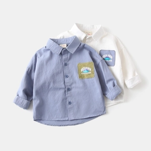 Detail view of cotton boy shirts with dinosaur patch and buttoned collar in soft grey and white