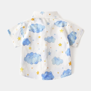 Detail view of cotton kids short sleeve shirt with blue clouds and yellow stars print