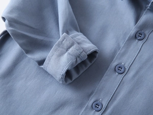 Detail view of the cuffs and matte buttons on this blue long-sleeved cotton shirt