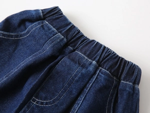 Détail du short en jean bleu foncé avec taille élastique renforcée et coutures blanches