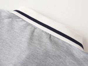 Detail of grey pique polo shirt collar with navy blue striped white ribbed neckline