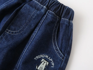 Détail du short en jean bleu foncé avec taille élastique et broderie tendance pour garçon