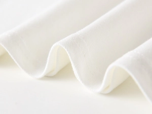Close-up of white cotton fabric texture and double-needle stitching on boys polo shirt