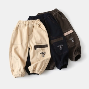 Detail of three-color boys cotton casual pants with elastic waist and puppy embroidery