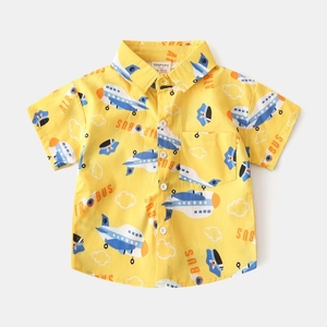 Close-up of yellow cotton shirt featuring airplane cartoon prints and chest pocket detail