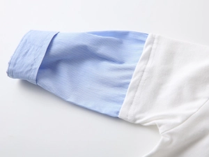 Detail of blue striped sleeve stitching and cuff on children's white cotton polo shirt