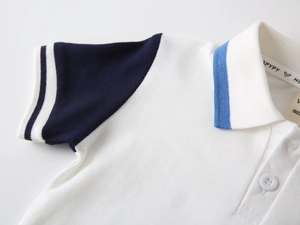 Close-up of boys' white cotton polo shirt showing pique fabric texture and blue collar