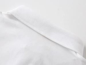 Detailed close-up of white cotton polo shirt collar with neat stitching and premium fabric