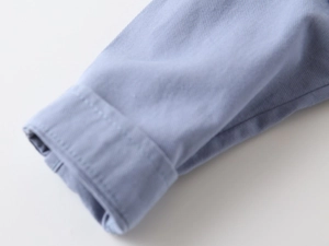 Detail of light blue twill fabric cuff showing clean stitching and high quality texture