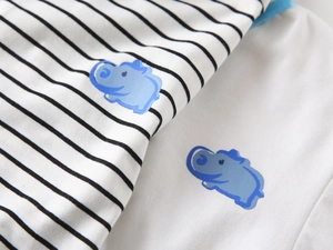 Detail of soft cotton fabric showing striped patterns and blue cartoon animal prints