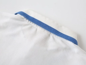 Detailed close-up of white cotton polo shirt collar with blue striped trim and piqué texture
