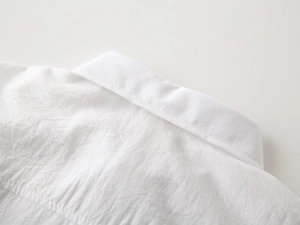 Close-up of classic collar and breathable cotton linen texture on white toddler shirt