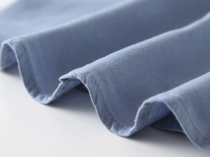 Detail view of cotton blue boy shirt showing fine stitching and twill fabric texture