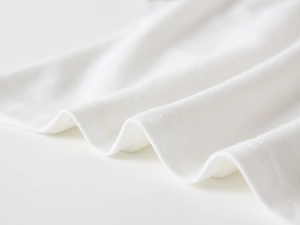Detailed macro shot of white cotton polo shirt showing neat double-needle stitching