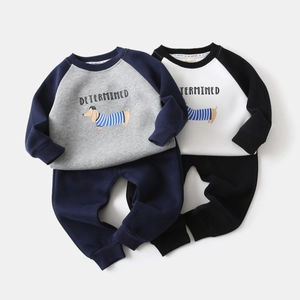 Flat lay detail of two kids' sportswear sets with raglan sleeves and cartoon dog prints