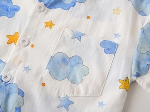 Close-up of boys white short sleeve shirt with blue cloud and yellow star prints