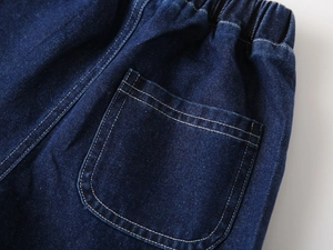 Détail du short en jean bleu foncé avec taille élastique et poche aux surpiqûres blanches