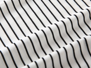 Close-up of soft black and white striped cotton fabric texture on children polo shirt