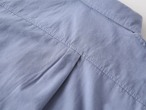 Macro detail of high-quality light blue cotton twill fabric and refined back pleat stitching