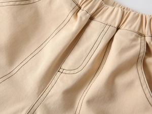 Detail of elastic waistband and contrast stitching on boys beige cotton twill pants