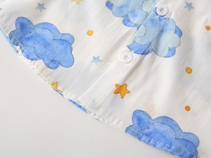 Macro detail of kids shirt showing white resin buttons and blue watercolor cloud prints