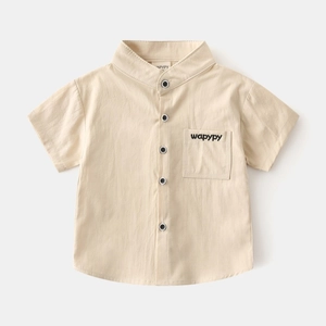 Detail of boys' beige V-neck short sleeve shirt with pocket and contrast buttons