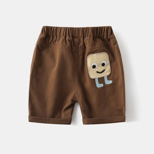 Detail of brown cotton canvas kids shorts with elastic waist and cute cartoon patch