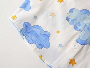 Close-up of cotton shirt with blue watercolor clouds, stars, and white resin button