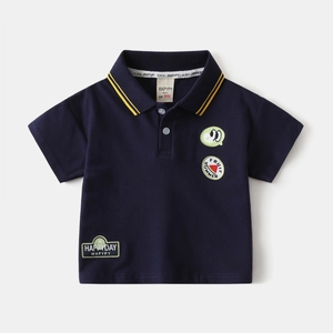 Détail du polo bleu marine avec rayures jaunes sur le col et broderies de dessin animé