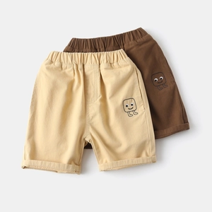 Detail of kids cotton shorts featuring elastic waistband and small smiley face embroidery