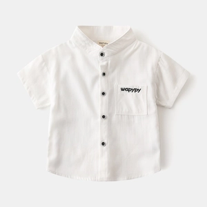 Detail of white cotton linen boy shirt with V-neck, black buttons and pocket embroidery