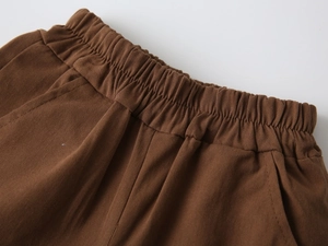 Detail view of dark brown toddler shorts featuring elastic waistband and side pocket stitching