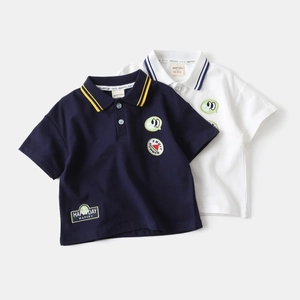 Détail du col d'un polo en coton avec rayures et badge pastèque de dessin animé