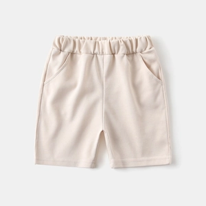 Detail of beige cotton boy's shorts with elastic waistband and side pockets