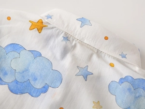 Close-up of cotton short sleeve shirt neckline with hand-drawn cloud and star prints