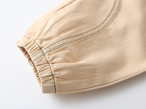 Detail of boys' khaki twill cotton trousers showing elasticated ankle cuffs and stitching