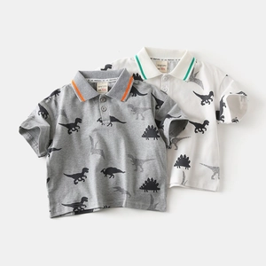Detail of kids polo shirts with all-over dinosaur prints in grey and white cotton