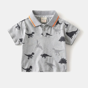 Close-up of children's grey polo shirt featuring dinosaur prints and orange collar detail