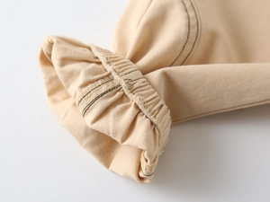 Detail of light khaki twill cotton fabric featuring elastic ribbed cuffs and neat stitching
