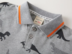 Detail of grey polo shirt with black dinosaur print and vibrant orange collar piping