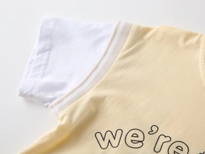 Detail of boys' cotton t-shirt with striped collar and we're graphic print