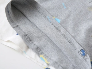 Macro view of double-stitched sleeve detail on kid's cotton polo with space-themed prints