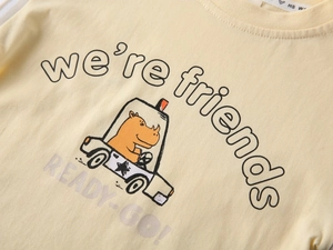 Detail of yellow cotton toddler tee with cartoon rhino print and crew neck texture
