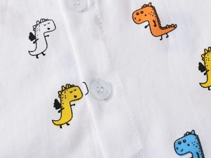 Close-up of white cotton boy's shirt with colorful dinosaur prints and neat button detail