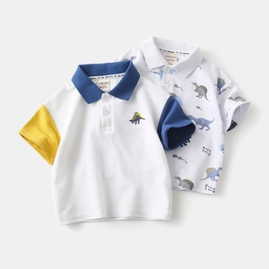 Detail of kids polo shirts showing piqué cotton texture and embroidered dinosaur patterns