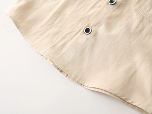 Macro detail of breathable beige linen fabric and textured buttons on boys' shirt