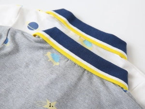 Detail showing the ribbed polo collar and space-themed prints on pique cotton fabric