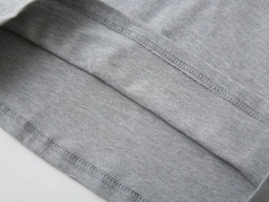 Détail de la couture à double aiguille sur un polo en maille grise pour garçons de mode