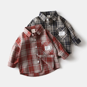 Detail view of the stitching and cotton fabric texture of two plaid shirts for kids